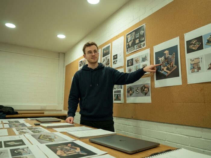 Étudiant présentant son portfolio 3D lors d'une revue de projet dans une école de formation artistique