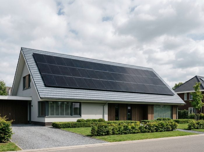 Maison individuelle avec toiture entièrement couverte de panneaux solaires photovoltaïques illustrant une installation optimale